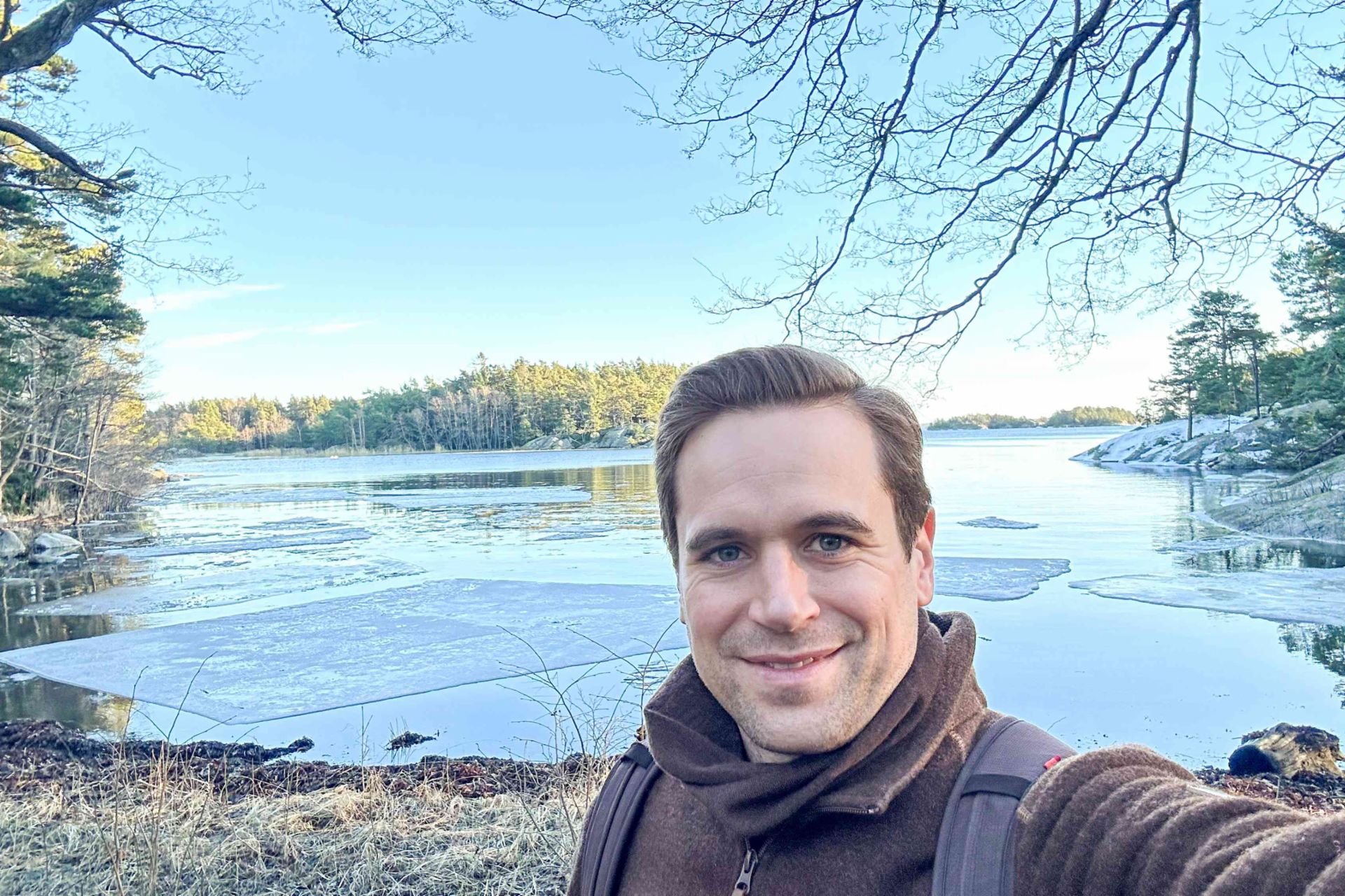 Selfi von Philipp Lassernig im Björnö Naturreservat. Im Hintergrund ein See umgeben von Wald.